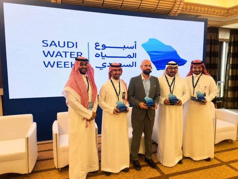 Mohammed Al Arag (centre) with session participants holding awards on stage in front of the Saudi Water Week backdrop.